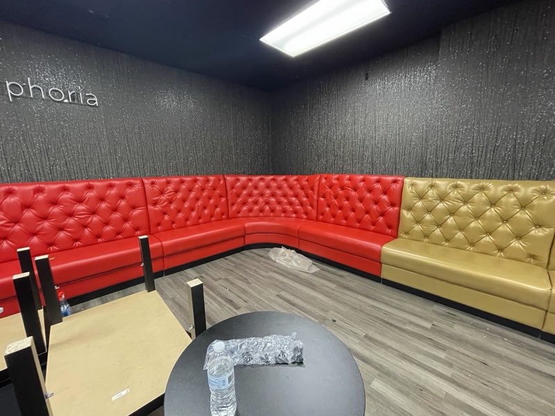 Custom red and tan tufted banquette seating in a commercial venue